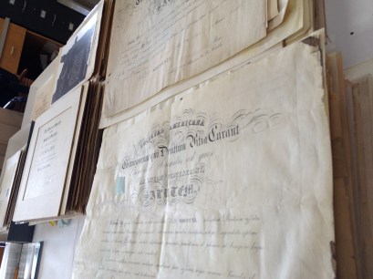 Piles of diplomas to be sorted, cleaned, and housed.