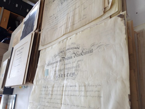 Piles of diplomas to be sorted, cleaned, and housed.