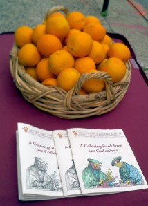 Coloring books and oranges, waiting for the start of the Museum Mile Festival.